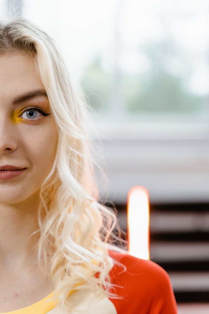 pexels-photo-7894408-7894408 Vibrant close-up portrait of a blonde woman with colorful eye makeup.