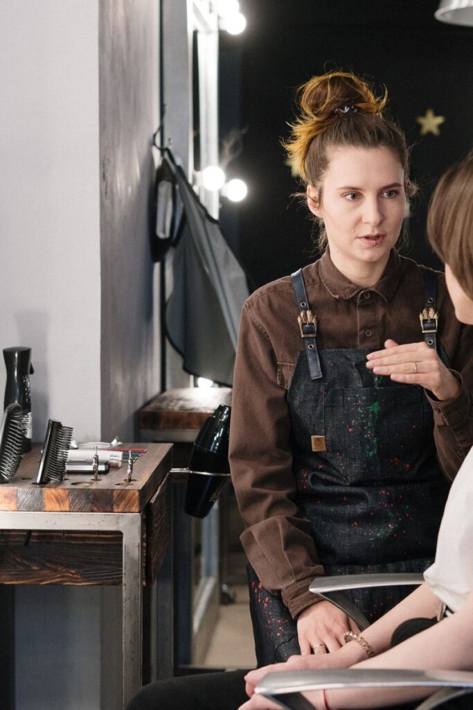 Hair stylist providing consultation to client in a modern salon setting.