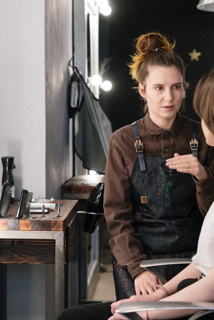 Hair stylist providing consultation to client in a modern salon setting.