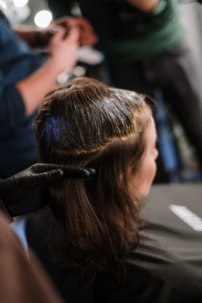 pexels-photo-3993323-3993323 Woman receiving hair coloring treatment in a modern salon setting.