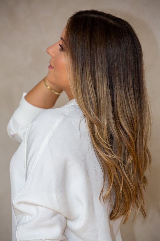 pexels-photo-8030666-8030666 Stylish side view portrait of a woman with long brunette hair wearing a white shirt.