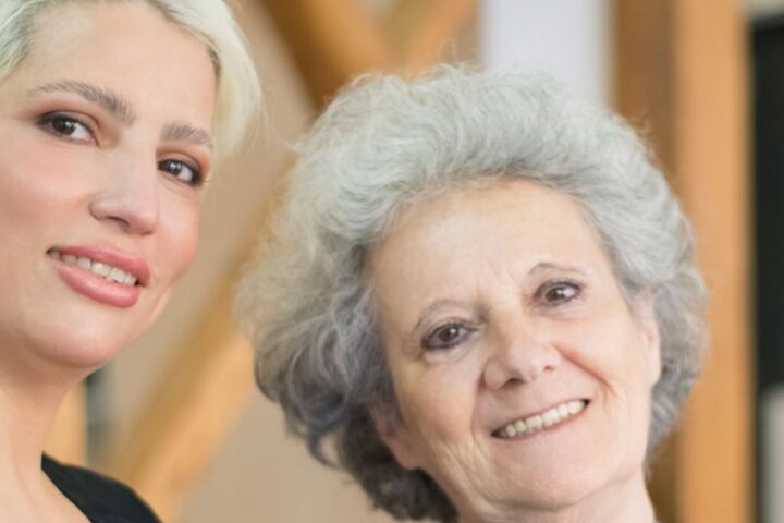 Smiling hair stylist with a happy elderly client in a modern salon setting